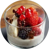 Joghurt mit frischen Beeren wie Erdbeere, Brombeere und roten Johannisbeeren in einem Gläschen.