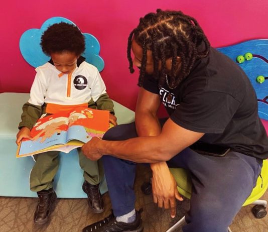 Michael Worthen, a member of The Library Dads, reads with his son.