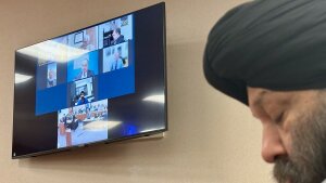 Harjinder Singh is seen on a video screen next to his attorney Tejinder Bains during court proceedings in Fort Pierce, Fla. on Thursday, Nov. 13, 2025.