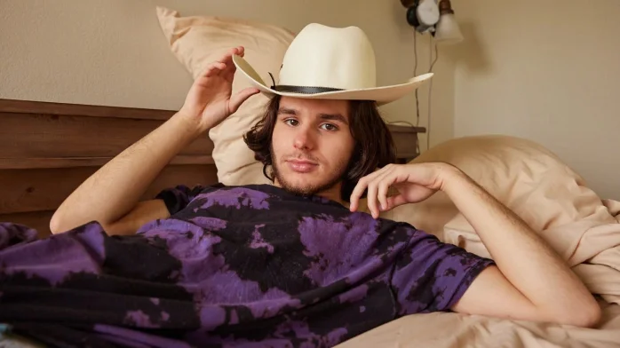 guy taking a photo with a cowboy hat