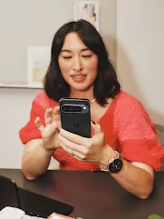 A person sits at a desk and holds a Pixel phone.