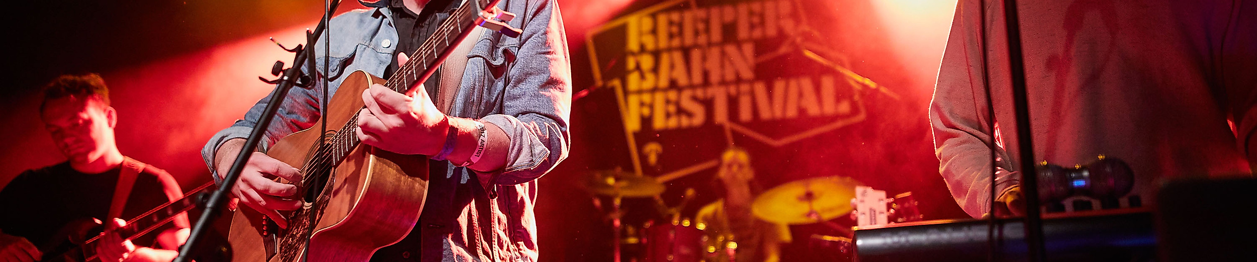 Zwei Musiker auf der Bühne beim Reeperbahn Festival in Hamburg mit bunter Lichtshow.