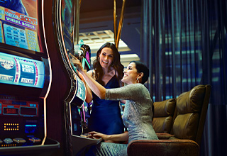 two women in casino playing slots